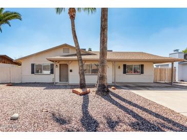 Charming single-story home featuring desert landscaping, a covered porch, and two palm trees at 2223 W 8Th Ave, Mesa, AZ 85202