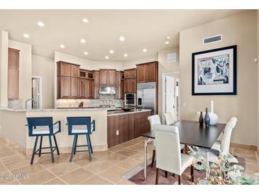 Open concept kitchen with stainless steel appliances, counter seating and adjacent dining area at 37015 N 27Th Pl, Cave Creek, AZ 85331
