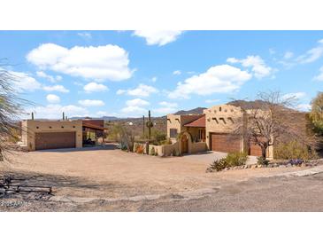 Desert home featuring a sand lot, garage, neutral stucco, and a terracotta-colored roof at 40108 N 2Nd Way, Phoenix, AZ 85086