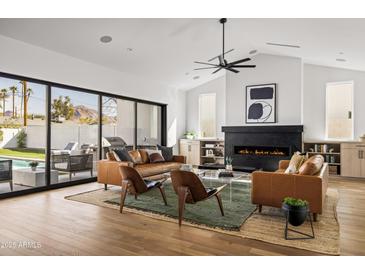 Bright living room boasts a modern fireplace, sleek furniture, and a seamless indoor-outdoor flow to the pool area at 4318 E Cheery Lynn Rd, Phoenix, AZ 85018