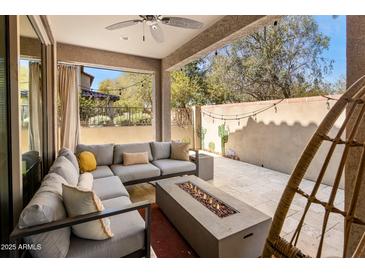 Relaxing outdoor patio area featuring a sectional couch, fire pit, and string lights at 4710 E Tierra Buena Ln, Phoenix, AZ 85032