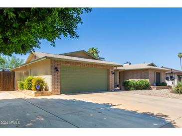 Charming single-story brick home featuring a well-manicured lawn and a spacious two-car garage at 4855 W Turquoise Ave, Glendale, AZ 85302