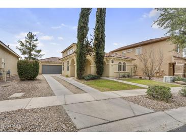 Charming home featuring a tile roof, desert landscaping, and a spacious driveway leading to a two-car garage at 863 E Waterview Pl, Chandler, AZ 85249