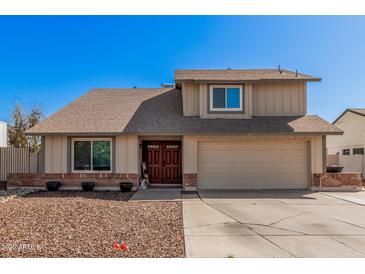 Two-story tan home featuring a two-car garage and a well-kept, low-maintenance front yard at 1027 W Natal Ave, Mesa, AZ 85210