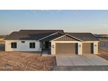Charming single-story home featuring a three-car garage and a modern, neutral color scheme in a desert environment at 20179 W Highland Ave, Litchfield Park, AZ 85340