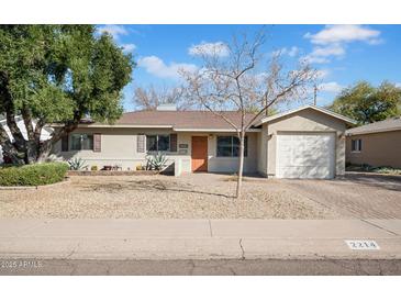 Charming single-story home with a well-maintained yard and an attached garage at 2214 E Sells Dr, Phoenix, AZ 85016