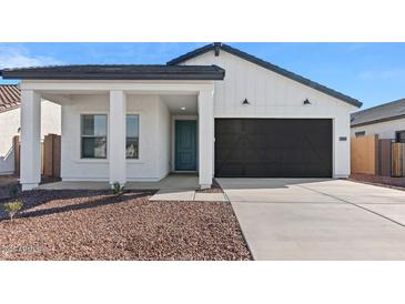 Charming single-story home showcasing a covered porch and a two-car garage at 3889 S 233Rd Ln, Buckeye, AZ 85326