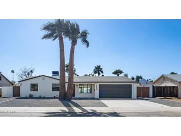 Charming single-story home featuring a two-car garage, desert landscaping, and tall palm trees at 3417 E Lupine Ave, Phoenix, AZ 85028