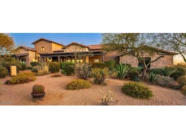 Expansive desert landscaping surrounds this beautiful home featuring stone accents and covered porch at 7413 E Lower Wash Pass, Scottsdale, AZ 85266