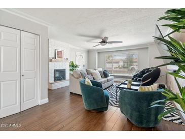 Comfortable living room with a fireplace, plush seating, and ample natural light from a window at 8213 E Whitton Ave, Scottsdale, AZ 85251
