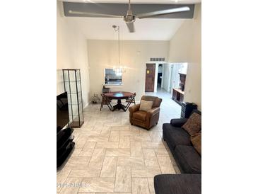 Bright living area features tile floors, high ceilings, stylish furniture, and a modern ceiling fan at 8302 N 21St Dr # L204, Phoenix, AZ 85021