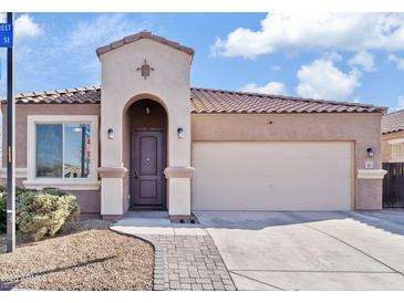 Charming single-story home with desert landscaping, arched entryway, and a two car garage at 1051 W Inca St, Mesa, AZ 85201