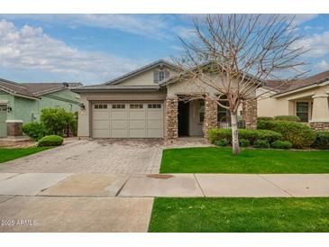Charming single-story home with a well-maintained lawn, paver driveway and stone accents on the front facade at 3527 E Arabian Dr, Gilbert, AZ 85296