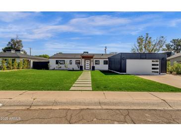 Beautifully renovated single story home with green grass, walkway and modern exterior at 4809 N 30Th Pl, Phoenix, AZ 85016