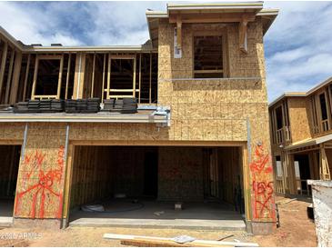 Unfinished new home construction, framed and boarded with open garage and a sunny sky backdrop at 5832 E Covey Ln, Phoenix, AZ 85054