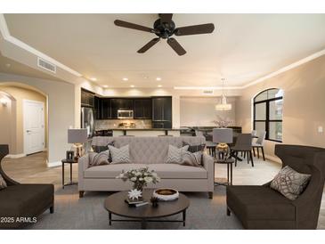 Staged living room with modern furniture, open to kitchen and dining area, and plenty of natural light at 7601 E Indian Bend Rd # 2056, Scottsdale, AZ 85250
