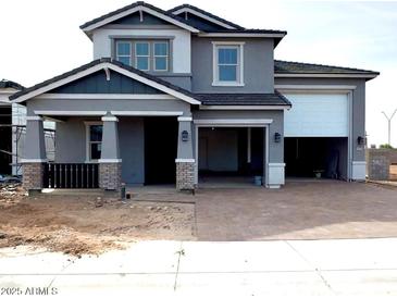 Attractive two-story home with a gray exterior, brick accents, and an attached two-car garage at 10039 W Verde Ln, Avondale, AZ 85392