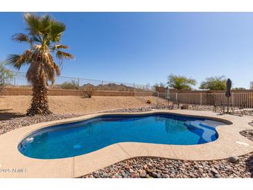 Backyard pool features desert landscaping and a palm tree, creating a relaxing outdoor oasis at 10287 S 175Th Ave, Goodyear, AZ 85338
