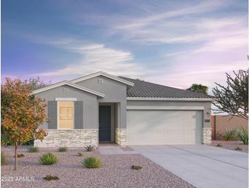 Charming single-story home with a neutral color scheme, stone accents, desert landscaping, and a two-car garage at 12564 W Trumbull Rd, Avondale, AZ 85392