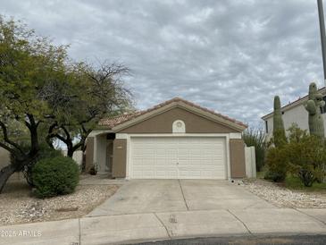 Charming single-story home featuring a two-car garage, desert landscaping, and a tiled roof at 4402 E Creosote Dr, Cave Creek, AZ 85331
