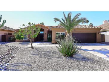 Charming home featuring a well-maintained front yard, desert landscaping and a cozy, covered entryway at 6323 E Nisbet Rd, Scottsdale, AZ 85254