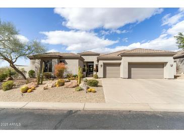 Charming single-story home with a three-car garage and desert landscaping in front at 6340 E Marioca Cir, Scottsdale, AZ 85266
