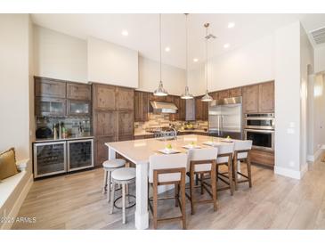 The spacious kitchen features an island with seating, pendant lighting, and high-end stainless steel appliances at 7739 E Evening Glow Dr, Scottsdale, AZ 85266
