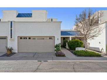 Charming home exterior featuring a beige garage, blue roof accents, and well-maintained landscaping at 10 W Georgia Ave # 8, Phoenix, AZ 85013