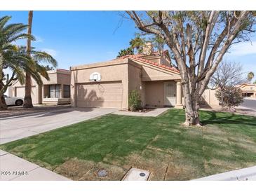 Charming single-Gathering home with well-manicured lawn, complemented by desert landscaping and neutral color palette at 1518 E Mineral Rd, Gilbert, AZ 85234