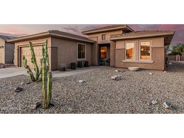 Charming home with desert landscaping and a large saguaro cactus in the front yard at 19975 N Crescent Way, Surprise, AZ 85374