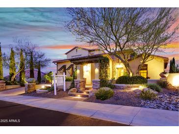 Inviting single-Gathering home featuring a landscaped front yard and a charming covered entryway with stone accents at 28689 N 67Th Dr, Peoria, AZ 85383