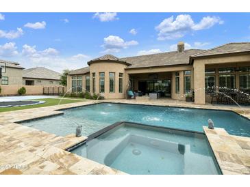 An expansive backyard boasts a sparkling pool, spa, and lush landscaping, perfect for outdoor living and entertaining at 3314 E Kael St, Mesa, AZ 85213