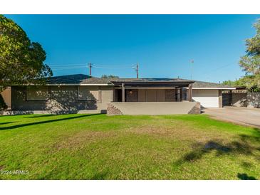 Charming single-story home featuring well-kept front yard and covered porch with stone accents at 346 E Highland Ave, Phoenix, AZ 85012