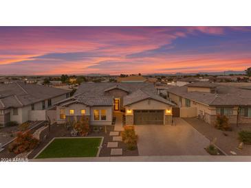 Charming home featuring landscaped yard, desert plants, a brick driveway, and a two car garage under a colorful sunset at 3502 E Hazeltine Way, Queen Creek, AZ 85142