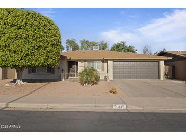 Charming single-story home with a well-maintained desert landscape and an attached two-car garage at 445 S Omaha --, Mesa, AZ 85206