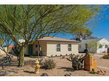 Charming single-story home with xeriscaping, vibrant tree, and a bright turquoise front door at 4539 N 9Th Ave, Phoenix, AZ 85013