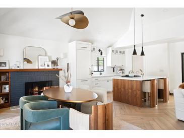 Open-concept living room showcasing a modern kitchen, dining area with fireplace, and stylish furnishings at 521 W Cambridge Ave, Phoenix, AZ 85003