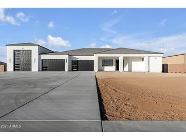 Striking modern home with a concrete driveway and 3-car garage at 1602 E Cloud Rd, Phoenix, AZ 85086