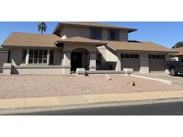 Charming home featuring a covered entry, manicured gravel yard, and attached two-car garage at 2634 E Fountain St, Mesa, AZ 85213