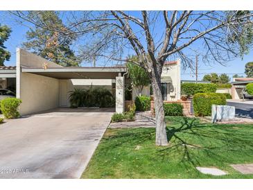 Charming single-story home with a covered carport and lush green lawn, perfect for suburban living at 2910 E Avenida Olivos --, Phoenix, AZ 85016