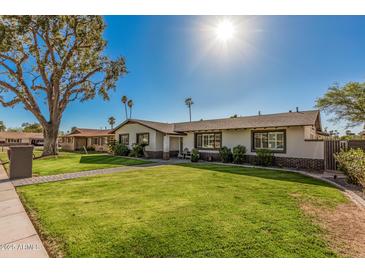 Well-manicured front yard with green lawn and a brick pathway to the home at 3016 N 49Th St, Phoenix, AZ 85018