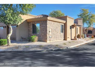 Beautiful home exterior with a stone facade, desert landscaping, and a tile roof at 4241 N Pebble Creek Pkwy # 54, Goodyear, AZ 85395