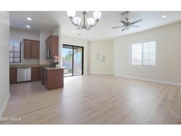 Bright, open-concept living space featuring hardwood floors and a sliding glass door to the patio at 4241 N Pebblecreek Pkwy # 54, Goodyear, AZ 85395