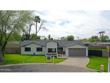 Charming single-story home with manicured lawn, two-car garage, and inviting front entrance at 7801 N 4Th Pl, Phoenix, AZ 85020