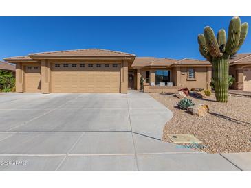 Single Gathering home boasts a huge garage, desert landscaping, and covered front porch at 11062 E Ocaso Ave, Mesa, AZ 85212