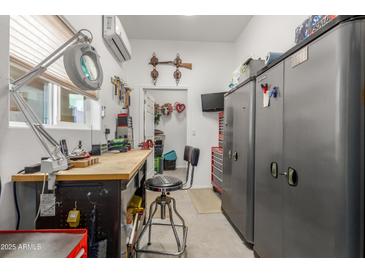 Well-lit workshop with functional workbench, tool storage, and climate control, ideal for hobbies at 11121 E Onza Ave, Mesa, AZ 85212
