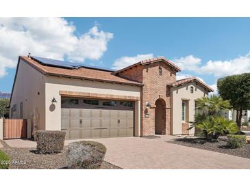 Charming single Gathering home displaying desert landscaping, solar panels, and a brick embellished archway entry at 12708 W Auburn Dr, Peoria, AZ 85383