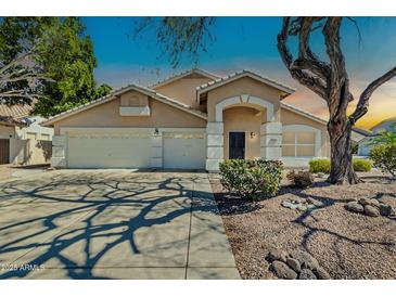 Charming single-story home features a three-car garage and a well-maintained front yard with desert landscaping at 20615 N 55Th Ave, Glendale, AZ 85308