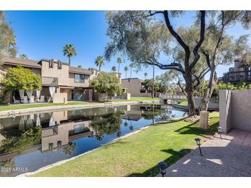 Waterfront condos with balconies and palm trees are reflected in the waterway at 2338 W Lindner Ave # 22, Mesa, AZ 85202