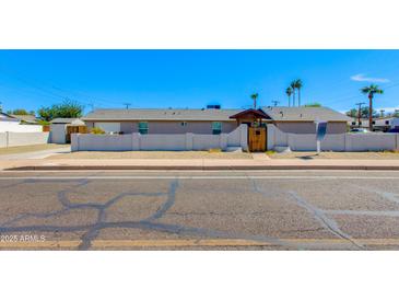 Charming single-story home with a welcoming front yard and a secure, wooden gate at 3601 N 12Th St, Phoenix, AZ 85014